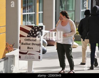 Milwaukee, WI, États-Unis. 1er novembre 2020. Un résident de Milwaukee dépose son bulletin dans l'urne officielle de la bibliothèque Eastside pour voter aux élections présidentielles américaines le dimanche 1er novembre 2020 le dernier jour pour le vote par anticipation crédit: Pat A. Robinson/ZUMA Wire/Alay Live News Banque D'Images