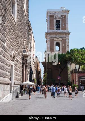 Les gens qui marchent à travers la Piazza Gesu Nuovo. Vue sur le clocher de Santa Chiara à Naples, Italie Banque D'Images