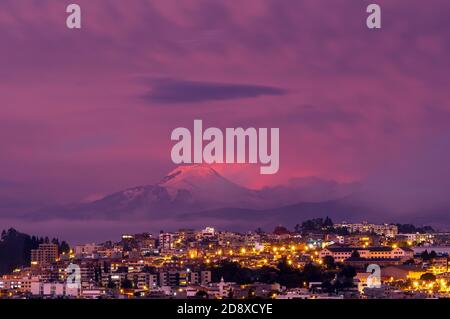 Coucher de soleil violet dans la ville de Quito avec le volcan Cayambe en arrière-plan, Equateur. Banque D'Images