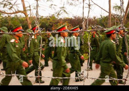 Un groupe de jeunes soldats vietnamiens s'entraîne derrière une clôture barbelée lors du programme de visite des académies militaires vietnamiennes de Dien bien Phu. Banque D'Images