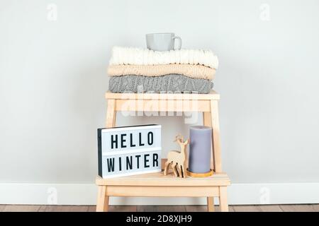 Une pile de pulls et décoration de Noël sur une chaise. Intérieur de la salle de séjour. La notion de confort d'hiver et confortable. Scandinave blanc Banque D'Images