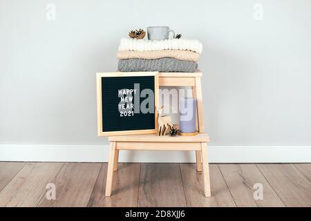 Une pile de pulls et décoration de Noël sur une chaise. Intérieur de la salle de séjour. La notion de confort d'hiver et confortable. Scandinave blanc Banque D'Images