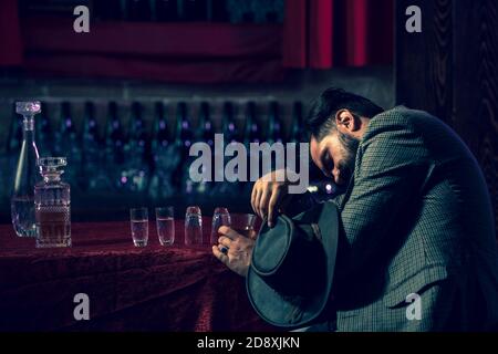 Homme ivre tenant le verre. Client de pub de bière dormant et allongé avec sa tête sur la table. Concept d'abus d'alcool et de toxicomanie. Banque D'Images