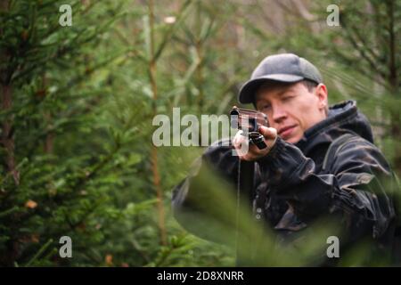 Chasseur visant un fusil de chasse dans une forêt Banque D'Images