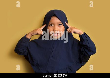 Le portrait d'une petite fille asiatique musulmane hijab pense Banque D'Images