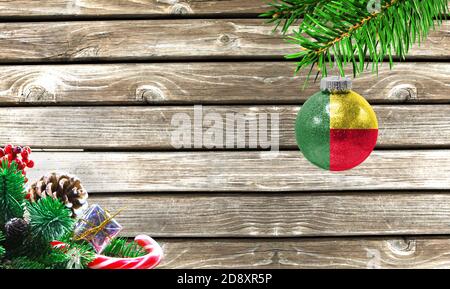 Concept du nouvel an et de Noël, sur fond de bois, branches d'arbres de Noël et jouet de Noël avec le drapeau du Bénin. Banque D'Images