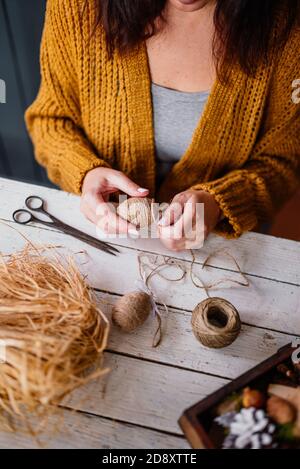 Femme créant un oeuf de pâques décoratif avec corde Banque D'Images