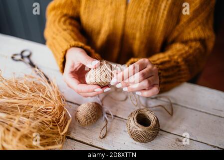 Femme créant un oeuf de pâques décoratif avec corde Banque D'Images