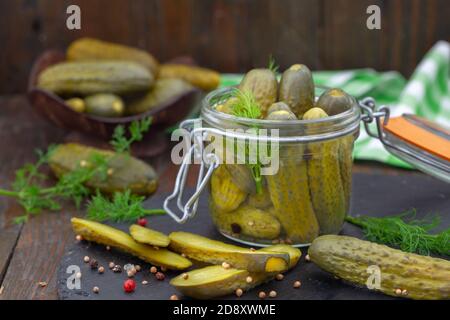 Concombres marinés avec herbes et épices sur fond de bois. Cornichons marinés faits maison dans un pot. Banque D'Images