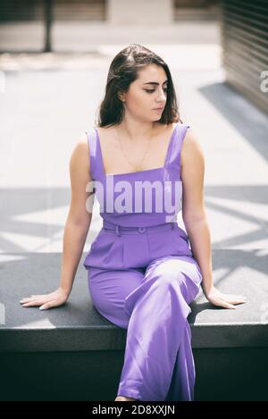 Triste jeune femme assise sur un banc à l'extérieur Banque D'Images