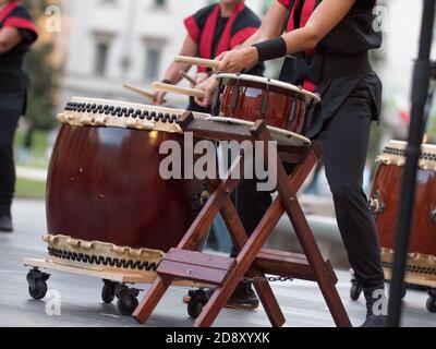 Girsl jouant des tambours de la tradition musicale japonaise lors d'un événement public en plein air. Banque D'Images