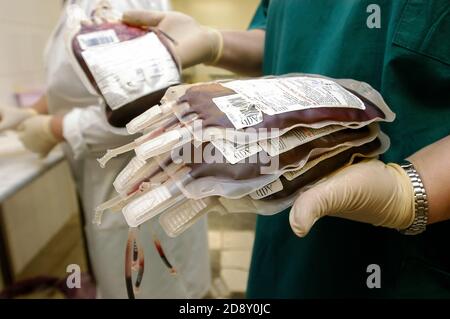 la main du scientifique tient un sac de sang rouge dans le laboratoire D'une banque de sang. Le médecin sélectionne du sang de donneur frais Pour la transfusion.concept de vie Banque D'Images