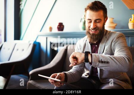 Concept de gestion des affaires et du temps. Homme d'affaires heureux regardant la montre de poignet. Banque D'Images