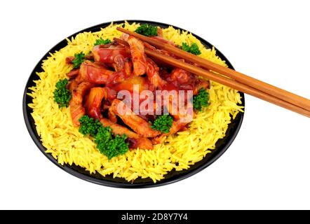 Porc doux et aigre chinois avec du riz sur un noir plaque isolée sur un fond blanc Banque D'Images