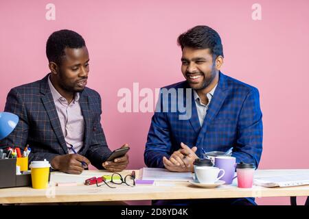 Un jeune homme africain montrant sa nouvelle application sur son téléphone, en utilisant les services bancaires mobiles. Business, Technology, Work break concept Banque D'Images