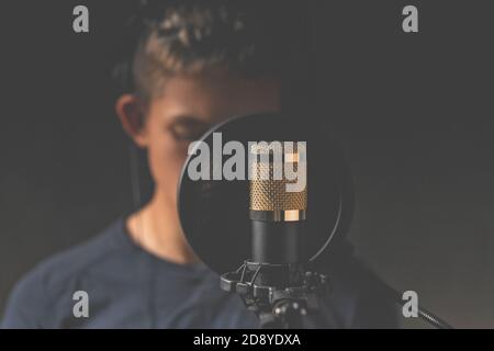 Microphone studio pour l'enregistrement sonore. Le chanteur en arrière-plan flou. Éclairage des touches bas Banque D'Images