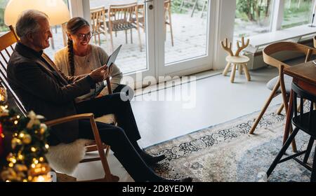 La famille se connecte en ligne avec ses amis à l'aide d'une tablette numérique pendant Noël. Fête de Noël avec la famille lors d'un appel vidéo. Banque D'Images