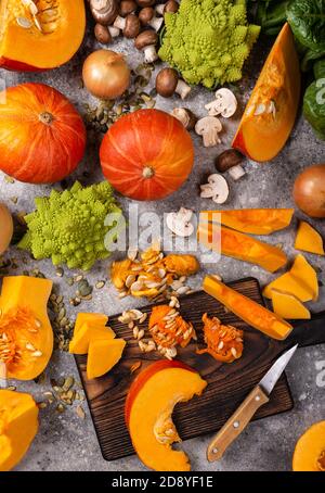 Concept de menu végétalien. Légumes et légumes verts de citrouille biologiques avec planche à découper sur la table. Banque D'Images