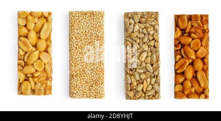 Diverses barres de noix de granola isolées sur fond blanc. Barres énergétiques saines avec arachides, sésame et caramel vue du dessus Banque D'Images