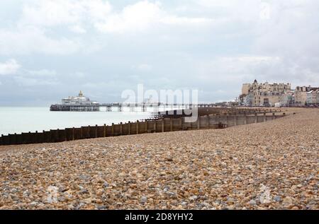 La plage de galets d'Eastbourne dans l'est du Sussex avec le célèbre Eastbourne quai de plaisance au-dessus de la mer au loin Banque D'Images