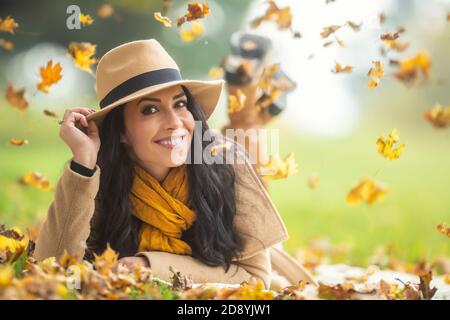 Une bonne femme dans un chapeau se trouve dans la nature entourée de feuillage. Banque D'Images