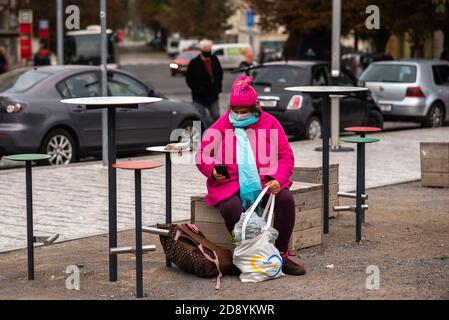 Femme portant un masque reposant avec des sacs lourds pendant la période de quarantaine en raison de l'éclosion de COVID-19 comme l'hiver commence. Prague, République tchèque Banque D'Images