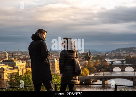 Homme et femme marchent et parlent sur le parc de Letna tout en ayant une vue spectaculaire sur le centre-ville à l'automne 2020 sur Prague 6, pendant la quarantaine p Banque D'Images