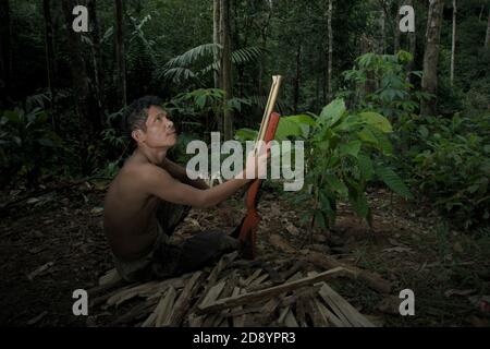 Tohab Hutagalung, un villageois fermier, tenant une carabine à air comprimé à la recherche d'une autre source de protéines au milieu de la forêt de Batang Toru à Sitahuis, Central Tapanuli, North Sumatra, Indonésie. Les communautés vivant dans la forêt tropicale et autour de celle-ci dépendent en partie de la chasse alimentaire et de la collecte alimentaire en plus de l'agriculture. Les conservationnistes ont résolu ce problème en plaçant l'autonomisation des communautés comme partie intégrante de tout effort de conservation de la nature, en fournissant éducation et assistance aux communautés pour trouver une source de revenu alternative plus durable et plus écologique. © Reynold Sumayku Banque D'Images