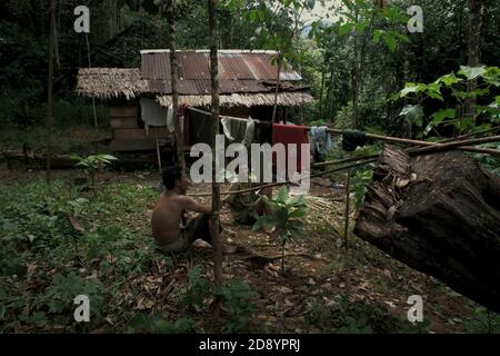 Tohab et Ramli Hutagalung, fermiers, ayant un repos à leur cabane de ferme dans une zone forestière, qui sur la limite ouest de l'écosystème de Batang Toru à Sitahuis, Central Tapanuli, Nord Sumatra, Indonésie. Les communautés vivant dans la forêt tropicale et autour de celle-ci dépendent en partie de la chasse alimentaire et de la collecte alimentaire en plus de l'agriculture. Les conservationnistes ont résolu ce problème en plaçant l'autonomisation des communautés comme partie intégrante de tout effort de conservation de la nature, en fournissant éducation et assistance aux communautés pour trouver une source de revenu alternative plus durable et plus écologique. Banque D'Images