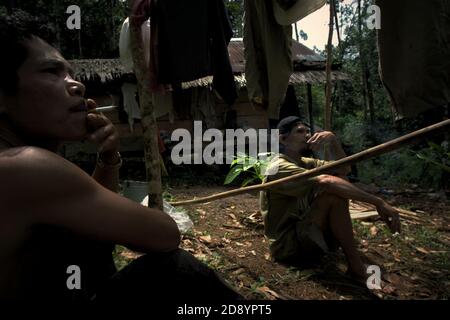 Tohab et Ramli Hutagalung, fermiers, ayant un repos à leur cabane de ferme dans une zone forestière, qui sur la limite ouest de l'écosystème de Batang Toru à Sitahuis, Central Tapanuli, Nord Sumatra, Indonésie. Les communautés vivant dans la forêt tropicale et autour de celle-ci dépendent en partie de la chasse alimentaire et de la collecte alimentaire en plus de l'agriculture. Les conservationnistes ont résolu ce problème en plaçant l'autonomisation des communautés comme partie intégrante de tout effort de conservation de la nature, en fournissant éducation et assistance aux communautés pour trouver une source de revenu alternative plus durable et plus écologique. Banque D'Images