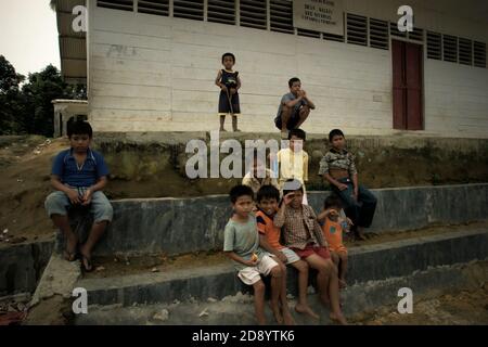 Portrait de groupe d'enfants villageois à la cour d'un bâtiment d'école primaire dans le village de Nauli à Sitahuis, un district situé à l'extrémité ouest du bassin versant de Batang Toru et de l'écosystème de la forêt tropicale dans le centre de la régence de Tapanuli, province de Sumatra Nord, Indonésie. Banque D'Images