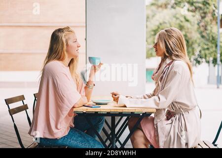 Deux belles filles blondes qui parlent au petit déjeuner. Banque D'Images