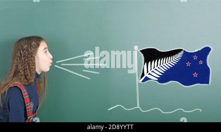 Une jeune fille qui soufflait sur le tableau scolaire est tirée sur le drapeau de la Nouvelle-Zélande. Photo haute résolution. Profondeur de champ complète. Banque D'Images