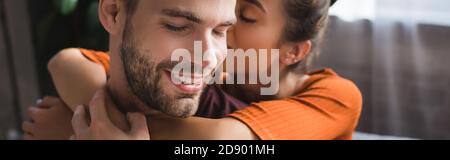 femme tendre embrassant un ami heureux et chuchotant dans son oreille, bannière Banque D'Images