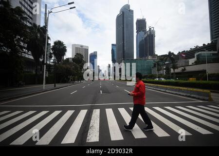 Jakarta, Indonésie. 2 novembre 2020. Un homme portant un masque facial marche dans une rue à Jakarta, Indonésie, le 2 novembre 2020. Credit: Zulkarnain/Xinhua/Alamy Live News Banque D'Images