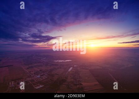 Paysage rural dans la soirée avec un beau ciel brûlant, vue aérienne. Vue panoramique sur la campagne au coucher du soleil Banque D'Images