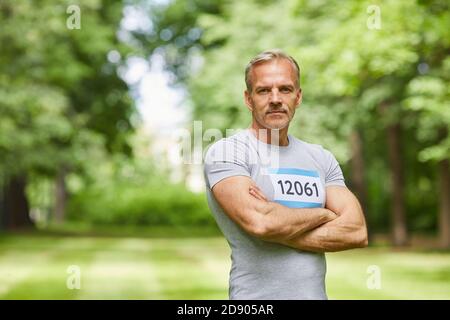 Portrait à la taille, photo d'un sportif caucasien expérimenté et confiant participant au marathon d'été debout au parc avec les bras croisés, espace de copie Banque D'Images