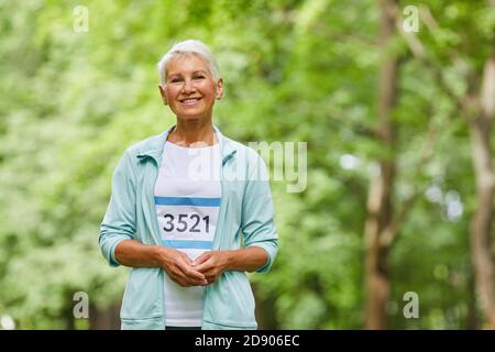 Portrait moyen d'une femme sportive agitée avec une coupe courte participant au marathon d'été en regardant l'appareil photo, l'espace de copie Banque D'Images