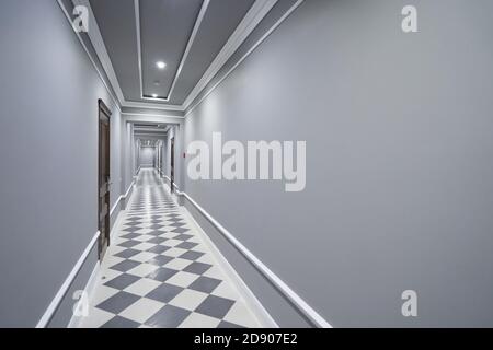 Couloir gris vide dans l'hôtel avec portes fermées Banque D'Images