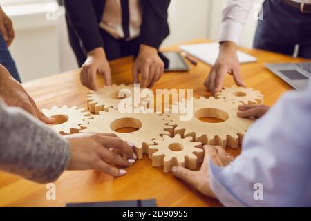 Image rognée d'employés de bureau fixant des engins en bois les uns aux autres sur un bureau dans le bureau. Banque D'Images