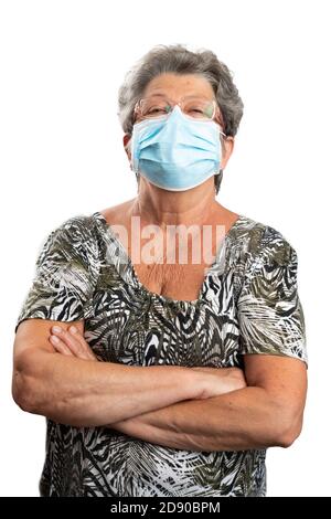 Portrait de femme âgée modèle debout avec les bras croisés port masque médical ou chirurgical couvrant le nez et la bouche à prévenir la grippe covid19 Banque D'Images