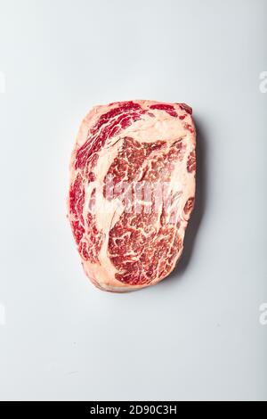 Le steak Rib Eye de bœuf marbré nourri au grain se trouve sur un fond blanc. Vue de dessus du bœuf marbré Banque D'Images