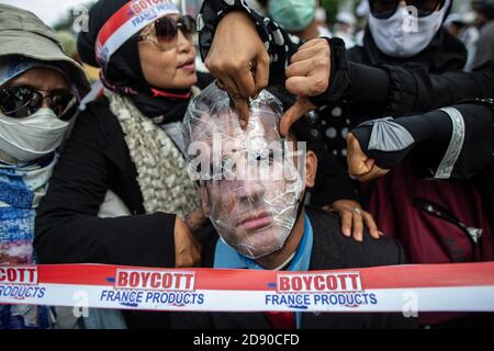 Jakarta, Jakarta, Indonésie. 2 novembre 2020. Les gens expriment leur colère contre une affiche avec la photo du président français Emmanuel Macron collée dans une rue en signe de protestation suite aux commentaires de Macron sur les caricatures du prophète Mohammed devant l'ambassade de France à Jakarta, Indonésie, le 2 novembre 2020. Le président français Emmanuel Macron est considéré comme ayant insulté l'islam et le prophète Mahomet. Les commentaires de Macron ont déclenché des protestations et un appel à boycotter les produits français dans certains pays à majorité musulmane. Credit: Afriadi Hikmal/ZUMA Wire/Alamy Live News Banque D'Images