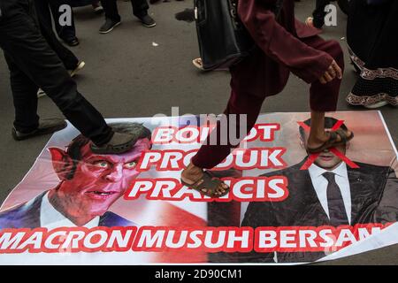 Jakarta, Jakarta, Indonésie. 2 novembre 2020. Les gens marchent sur une affiche avec la photo du président français Emmanuel Macron collée dans une rue en signe de protestation à la suite des commentaires de Macron sur les caricatures du prophète Mohammed devant l'ambassade de France à Jakarta, Indonésie, le 2 novembre 2020. Le président français Emmanuel Macron est considéré comme ayant insulté l'islam et le prophète Mahomet. Les commentaires de Macron ont déclenché des protestations et un appel à boycotter les produits français dans certains pays à majorité musulmane. Credit: Afriadi Hikmal/ZUMA Wire/Alamy Live News Banque D'Images