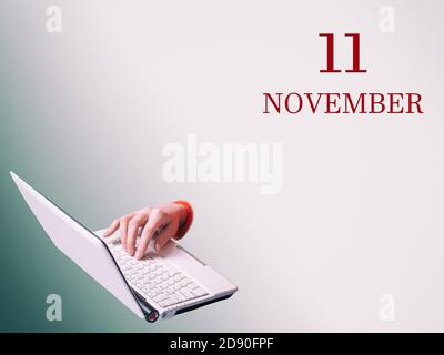 11 novembre. Une main tape sur un ordinateur portable l'annonce de la date d'une réunion d'affaires ou d'un événement Banque D'Images