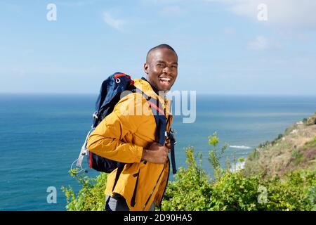 Portrait d'un homme afro-américain heureux avec sac à dos de marche à l'extérieur Banque D'Images