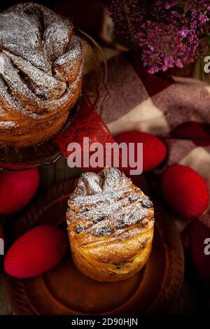 Gâteau de Pâques kraffin. Kraffins aux raisins secs, fruits confits et graines de pavot, saupoudrés de sucre en poudre. Gros plan sur un gâteau maison. Cruffin. Rouge Banque D'Images