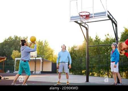 les joueurs de basket-ball en plein air. vacances d'été, vacances, jeux et concept d'amitié. les adolescents caucasiens dans les sweats à capuche décontractés engagés dans le sport, le mode de vie sain, concept de jeunesse Banque D'Images