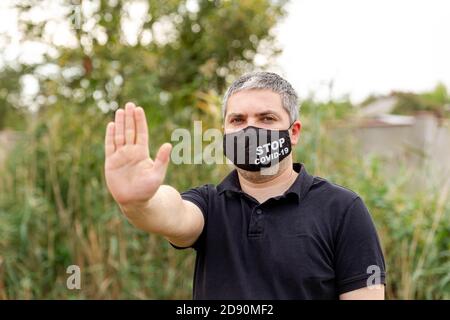 Masque de port humain tenant sa main pour arrêter COVID-19 virus Banque D'Images