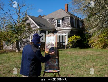 Un artiste au travail peint le Fuller Farmhouse historique à Barnstable, Massachusetts, États-Unis, un matin de fin d'automne Banque D'Images